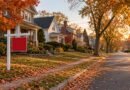 Illustrative autumn residential street with a blank for-sale sign and varied detached homes.